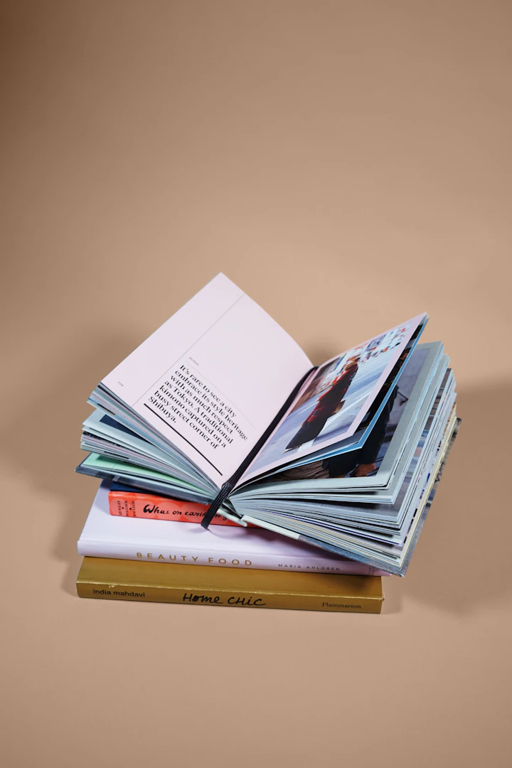 Capa da edição 44, livros empilhados sobre mesa antiga